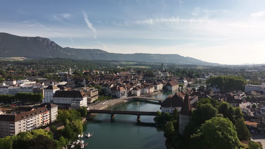 Aerial view of Olten, Switzerland, showing the Aare River, historic buildings, and surrounding mountains.