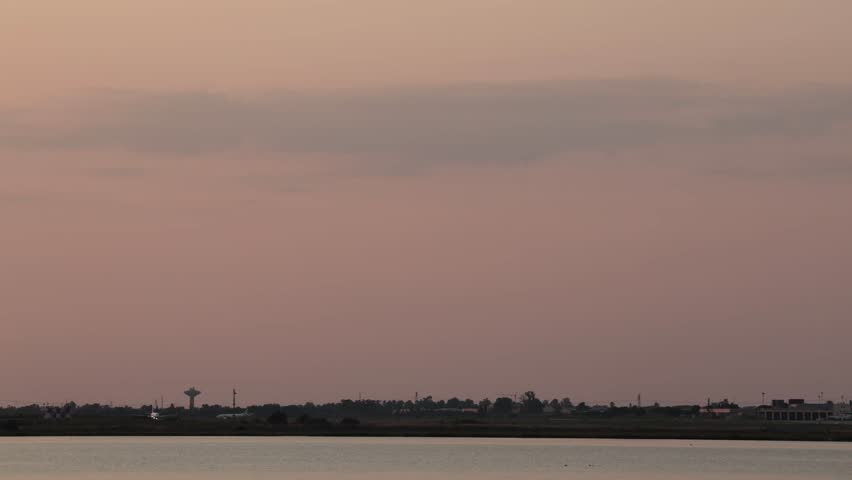 Cagliari, Sardinia, Italy A commercial airliner takes off at the Cagliari Elmas Airport at sunset.