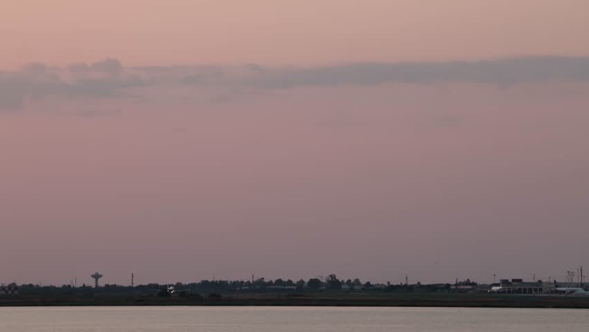 Cagliari, Sardinia, Italy A commercial airliner takes off at the Cagliari Elmas Airport at sunset.