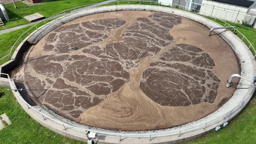 Aerial close up of wastewater treatment plant, filtration of dirty or sewage water. Sewage treatment plant at sunny day.