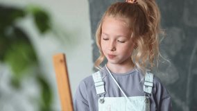 Portrait of young girl artist focusing on her painting, holding palette and brush during creative art lesson at home. Concept of children creativity, learning and artistic talent development. - Powered by Shutterstock - Get 15% off with code: PIKWIZARD15