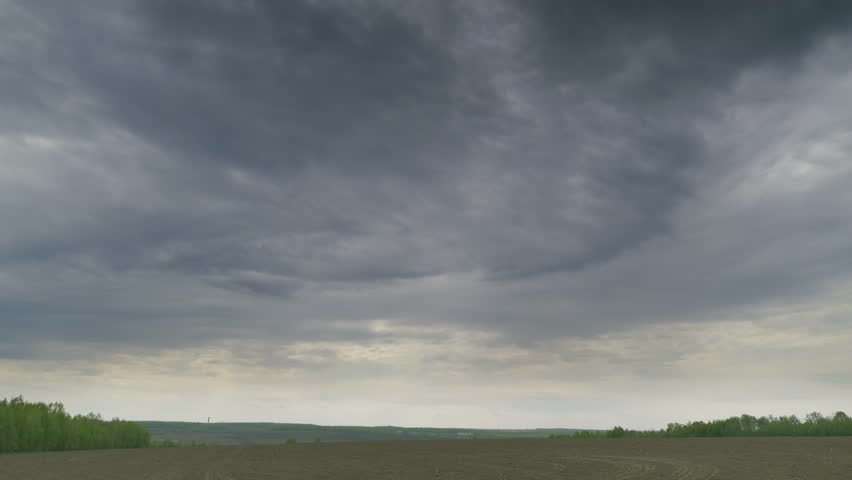 A Dramatic Cloudy Sky Over An Expansive Open Field Landscape That Captivates the Viewer