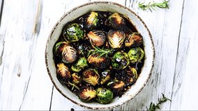 Top view of roasted Brussels sprouts in a ceramic bowl, garnished with rosemary, on a white rustic wooden table, healthy vegetarian side dish, vibrant and appetizing close-up. - Powered by Shutterstock - Get 15% off with code: PIKWIZARD15