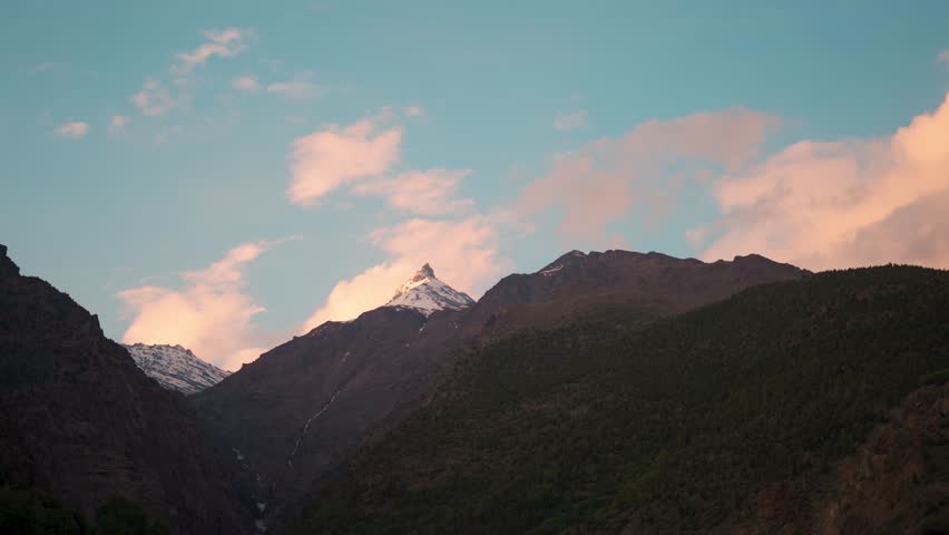 4K shot of Orange clouds above the Himalayan mountain range as seen during the sunset in Autumn season at Keylong in Lahaul Valley, Himachal Pradesh, India. Scenic sunset in the Himalayas.