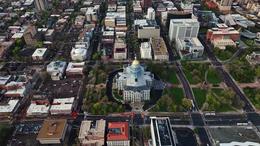Aerial view of the Colorado State Capitol building surrounded by green spaces and streets, blending architectural grandeur with urban design, Denver, Colorado, United States.