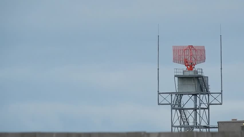 Air traffic control radar tower rotating across Welsh valley airport in Holyhead