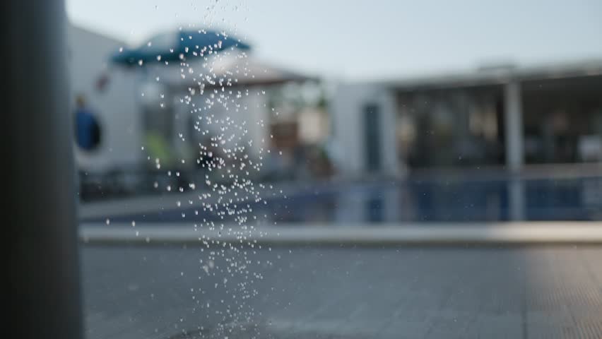 Refreshing water drops falling in swimming pool area