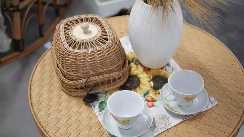 Handcrafted charm shines in this close-up footage featuring a woven food box and ceramic tea set displayed on a textured wooden surface
