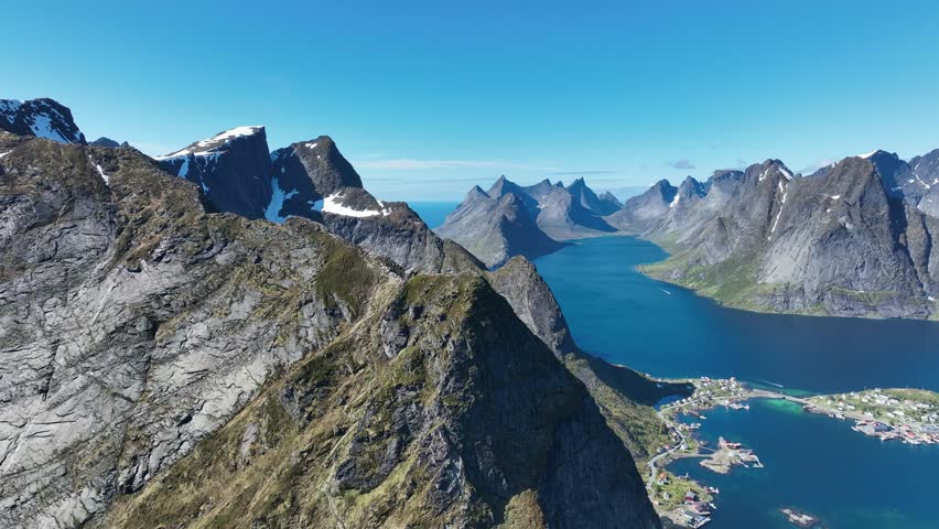 Orbiting Reinebringen cliff with Kjerkfjorden peaks parallaxing behind and Reine village below