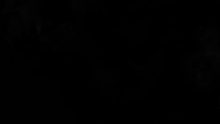 A small puff of white smoke exhaled into the air over a dark backdrop.