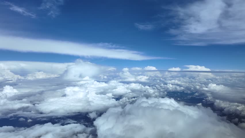immersive pilot’s view from cockpit while flying at cruise through a stormy sky, surroended by storm clouds in a deep blue sky. ultra-realistic 4K