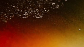 Macro view of shimmering gold particles swirling in brown, orange, and yellow ink forming abstract moving patterns. - Powered by Shutterstock - Get 15% off with code: PIKWIZARD15