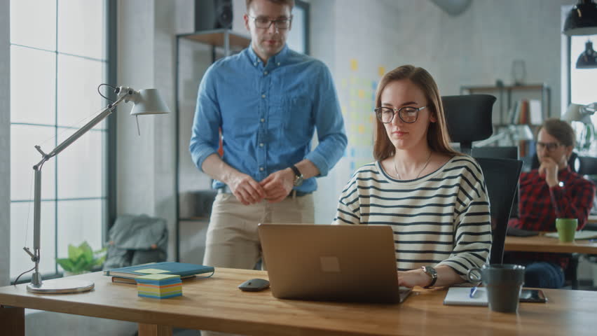 Young Professionals Engage in a Collaborative Office Setting, Discussing Project Strategies Around a Laptop. Team, Focuses on Creative Solutions and Teamwork on Digital Marketing and Ecommerce Startup