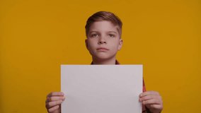 Boy Holding White Sheet of Paper for Unique Sign on Yellow Background - Powered by Shutterstock - Get 15% off with code: PIKWIZARD15