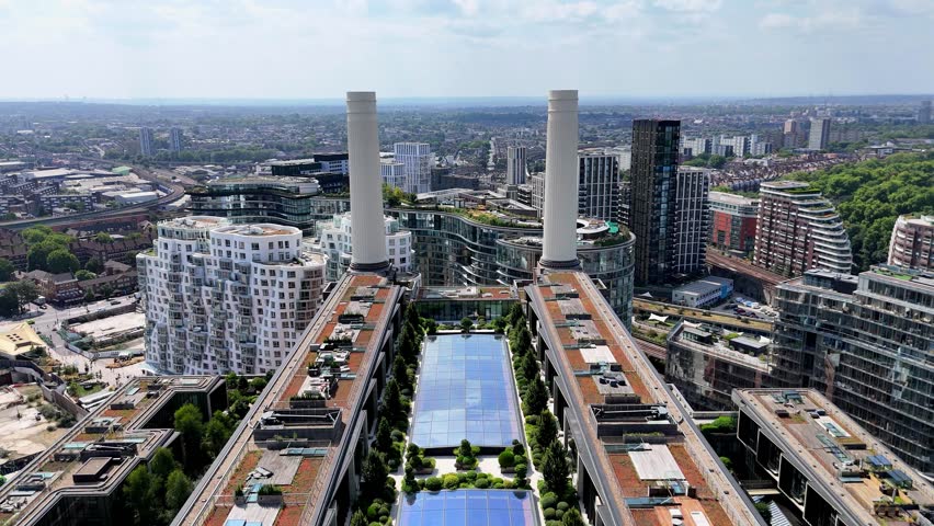 Dynamic drone fly-through between Battersea Power Station’s iconic chimneys in London, showcasing industrial design, skyline views, and the Thames waterfront in cinematic detail.