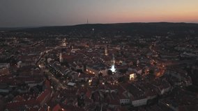 An aerial video of a historic European town during dusk, with warm streetlights illuminating the winding streets and iconic buildings. The fading light of sunset casts a soft glow over the rooftops. - Powered by Shutterstock - Get 15% off with code: PIKWIZARD15