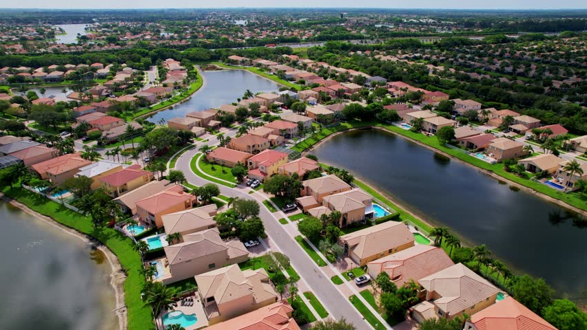 Establishing drone shot of residential area, lake and mansions during the day in Boca Raton, West Palm Beach, Florida, USA