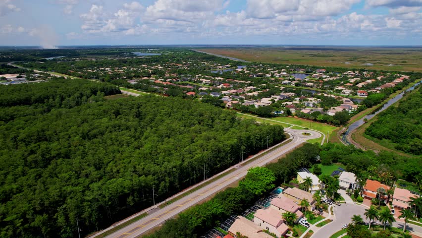 Aerial: residential area, forest and mansions during the day in Boca Raton, West Palm Beach, Florida, USA, establishing drone shot