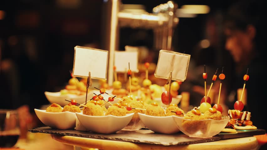Italian or Spanish restaurant with traditional tapas pinchos food, Spanish cuisine, delicious tapas and cheese plate, bruschetta with cheese, olives dry tomatoes tasty sandwich bar appetizer, buffet