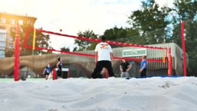 A group of young men are playing beach volleyball in a large city. - Powered by Shutterstock - Get 15% off with code: PIKWIZARD15