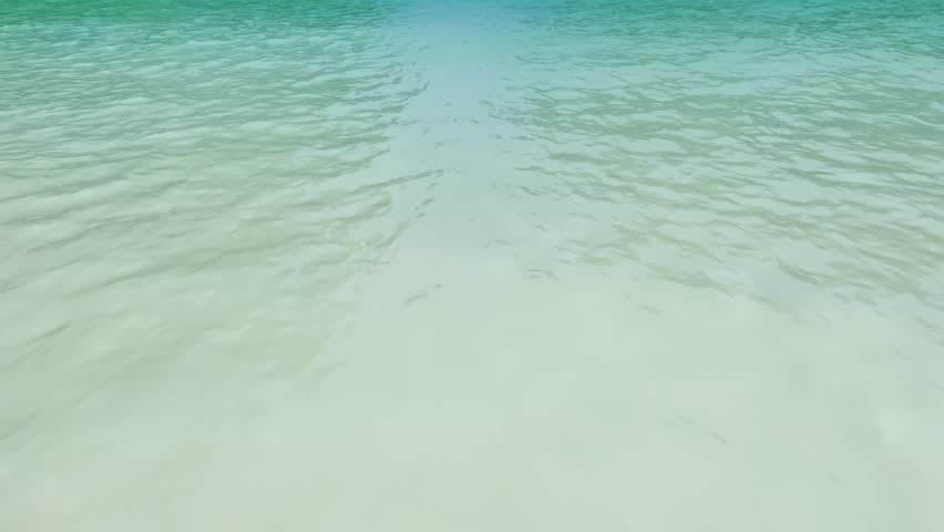 Scenic view of Maya Bay in Koh Phi Phi islands, Thailand with turquoise water, towering limestone cliffs, and boats in the distance under a clear blue sky