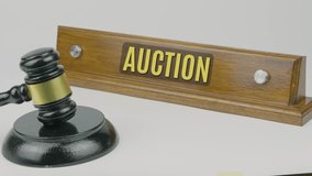 Auction word or text engraved on a wooden nameplate with a gavel tapping once and three times, symbolizing bidding, sale process, and legal transaction on a white background - Powered by Shutterstock - Get 15% off with code: PIKWIZARD15