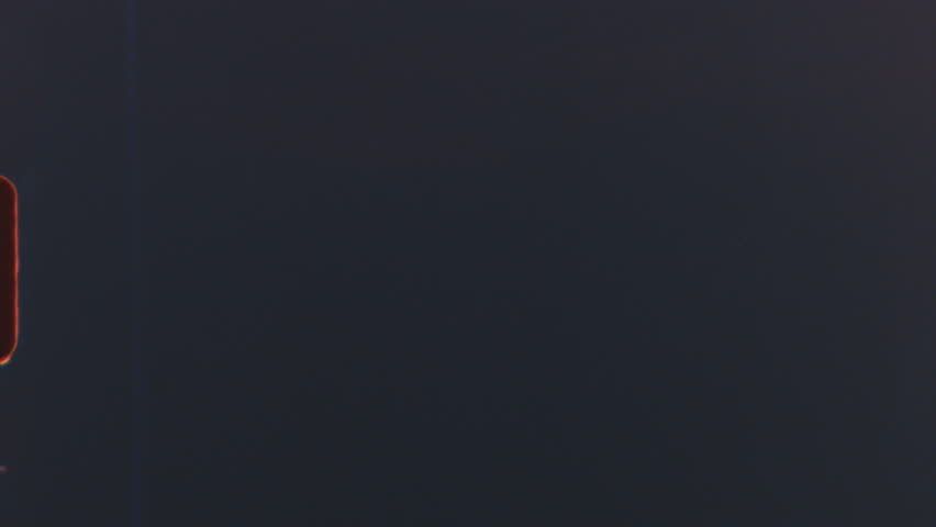 Abstract grainy texture from 8mm film reel with dark tones and light leaks