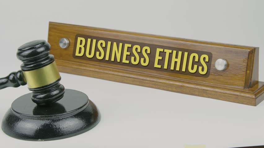 Business Ethics word or text engraved on a wooden nameplate with a gavel tapping once and three times, symbolizing moral principles, corporate responsibility, and legal compliance on a white backgroun