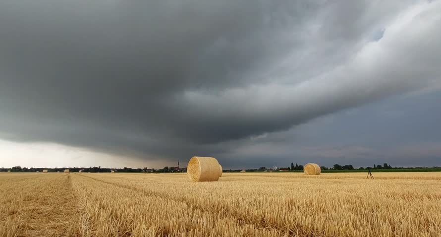 Golden Straw Bale Under Dramatic sky in the harvested wheat field in Hungary