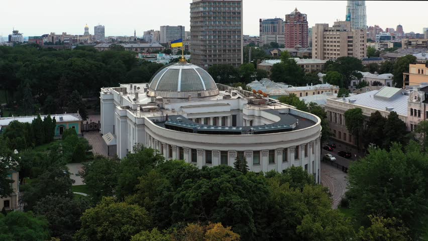 Ukrainian white house Verkhovna Rada parliament building. Waving Ukrainian flag. Urban Kiev city scape.