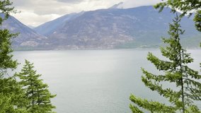 Peaceful mountain lake view framed by evergreen trees, with calm waters reflecting the serene beauty of nature. - Powered by Shutterstock - Get 15% off with code: PIKWIZARD15