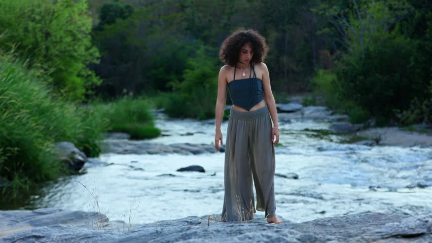 Reflective Moment by the Stream: A Young Woman Embraces Nature