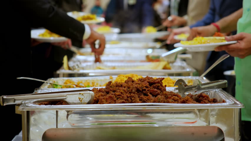 Close up shoot of the guests enjoying the catering buffet dishes with variety of the food at the venue on event. Above view