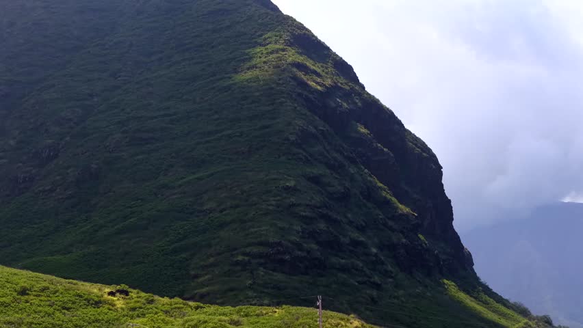 Lush green rugged face of a mountain in the Waianae range on Oahu, aerial