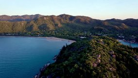 An aerial footage of the scenic Geoffrey Bay on Magnetic Island, Queensland, Australia at sunset, with green coastal mountains in the background - Powered by Shutterstock - Get 15% off with code: PIKWIZARD15