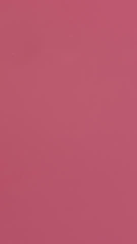 Vivid white paint dispersing in water against a fresh red backdrop, forming graceful swirling plumes—evoking fluid artistic beauty for creative motion design, visual effects, or ambient backgrounds