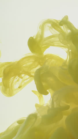 Vivid yellow paint dispersing in water against a fresh white backdrop, forming graceful swirling plumes—evoking fluid artistic beauty for creative motion design, visual effects, or ambient backgrounds