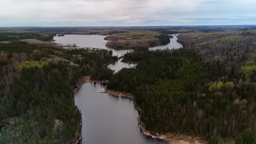 An aerial view of Northern Ontario Canadian wilderness in early spring with multiple fresh water lakes and vast forests