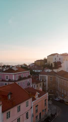A vertical view of pastel-colored homes in Lisbon Alfama neighborhood at early morning light