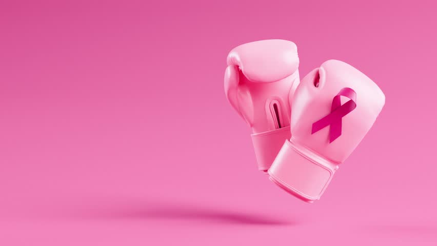 Looping video of pink boxing gloves with breast cancer awareness ribbon floating on a pink background and copy space in 3D animation. Pink October for the fight against breast cancer