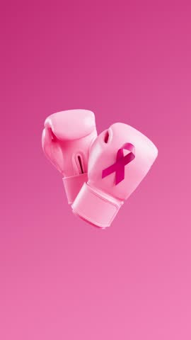 Looping video of pink boxing gloves with breast cancer awareness ribbon floating on a pink background and copy space for social media in 3D animation. Pink October against breast cancer