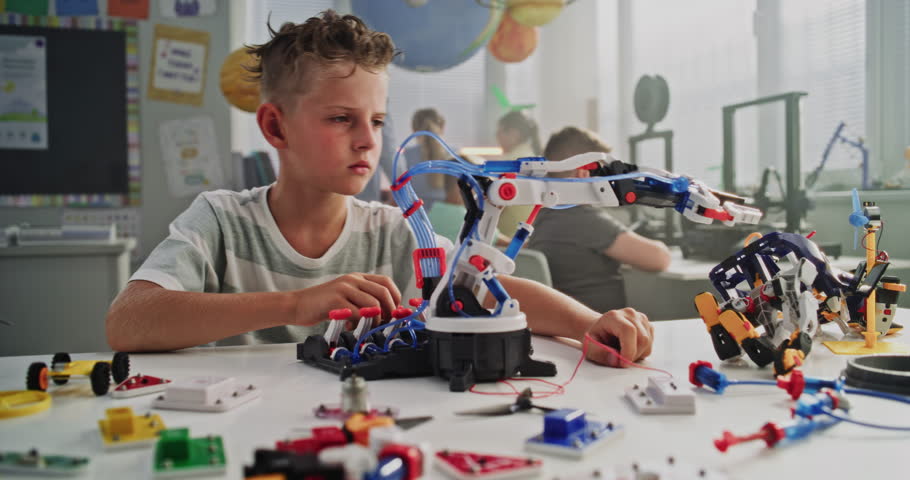 Talented Young Boy Studying Robotic Arm Model. Primary School Student Learning Science and Robotics Technology in Modern Classroom, Dreaming to Become Engineer. Creative Activity, STEM Education.