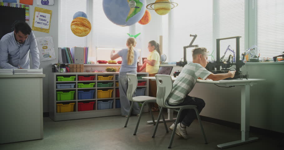 Talented Young Boys Studying Advanced Automated 3D Printer. Primary School Children Using Digital Devices, During Engineering and Programming Lesson in Modern Classroom. Interactive STEM Education.