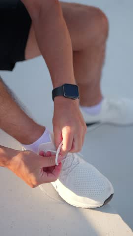 A focused individual secures their running shoes while preparing for an invigorating workout in the city.