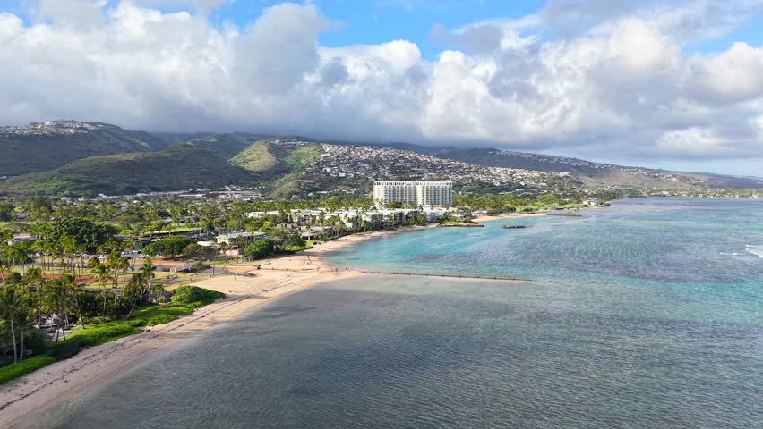 The Kahala Hotel on a sandy beach with palm trees in Honolulu Hawaii, aerial