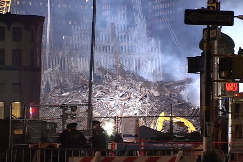 NEW YORK CITY - SEPTEMBER 28, 2001: Smoke rising from floodlit rubble with remains of World Trade Center structure in background.
