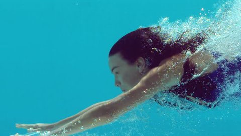 Woman swimming underwater in slow motion