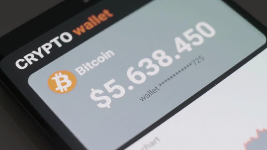 Close-up of a smartphone screen displaying a cryptocurrency wallet with a Bitcoin balance of over $5 million and a 'Buy' button.