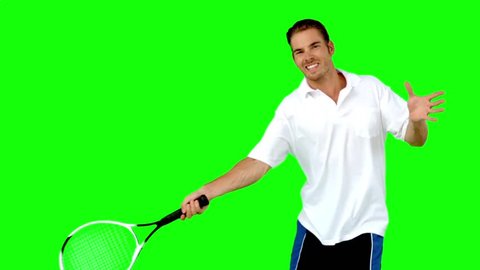 Young man playing tennis in slow motion on green screen