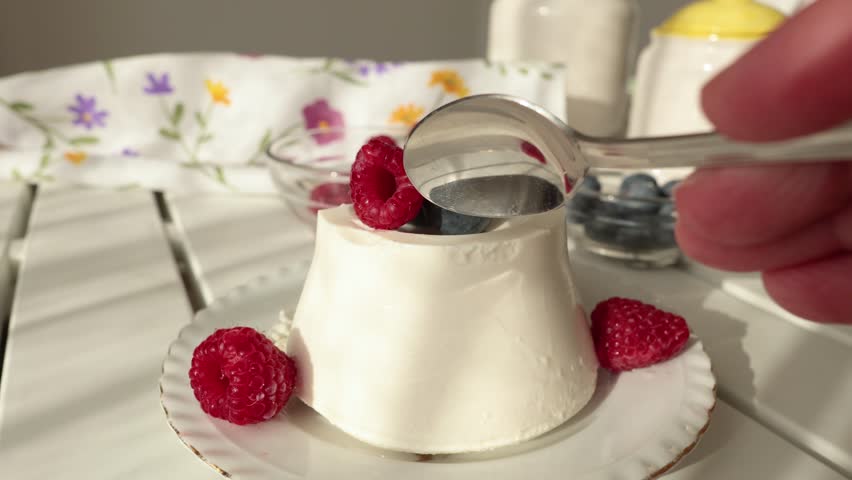 Woman and ricotta cheese dessert with berries. Table setting. Raspberries and blueberries. Healthy eating and vitamins. Environmentally friendly products. Mediterranean diet.